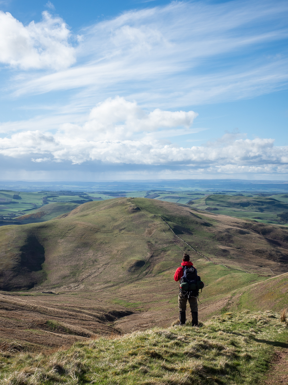A man reviews scenery on the Pennine Way long-distance footpath through the Cheviot Hills on the border between England and Scotland on 26 April 2018.