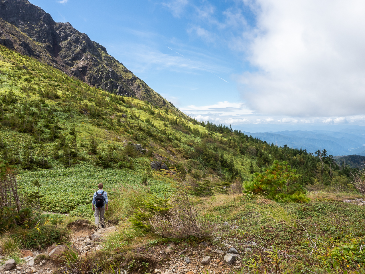 A hiker approaching the summit of Mount Yake, a volcano in Kamikōchi (the Upper Highlands) in the Hida Mountains, Nagano Prefecture, Japan.