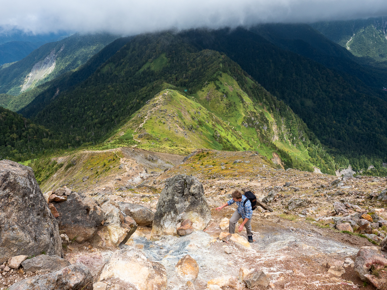 A hiker approaches the summit of Mount Yake, a volcano in Kamikōchi (the Upper Highlands) in the Hida Mountains, Nagano Prefecture, Japan.