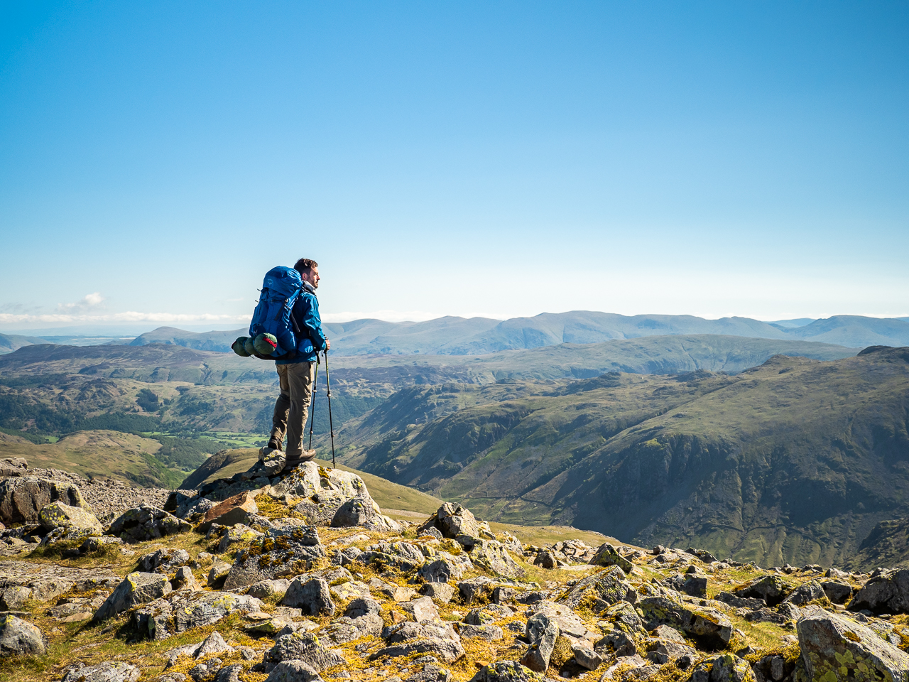 Travel photography England: A hiker views the horizon from Great Gable, a mountain in the Lake District, Cumbria, England.