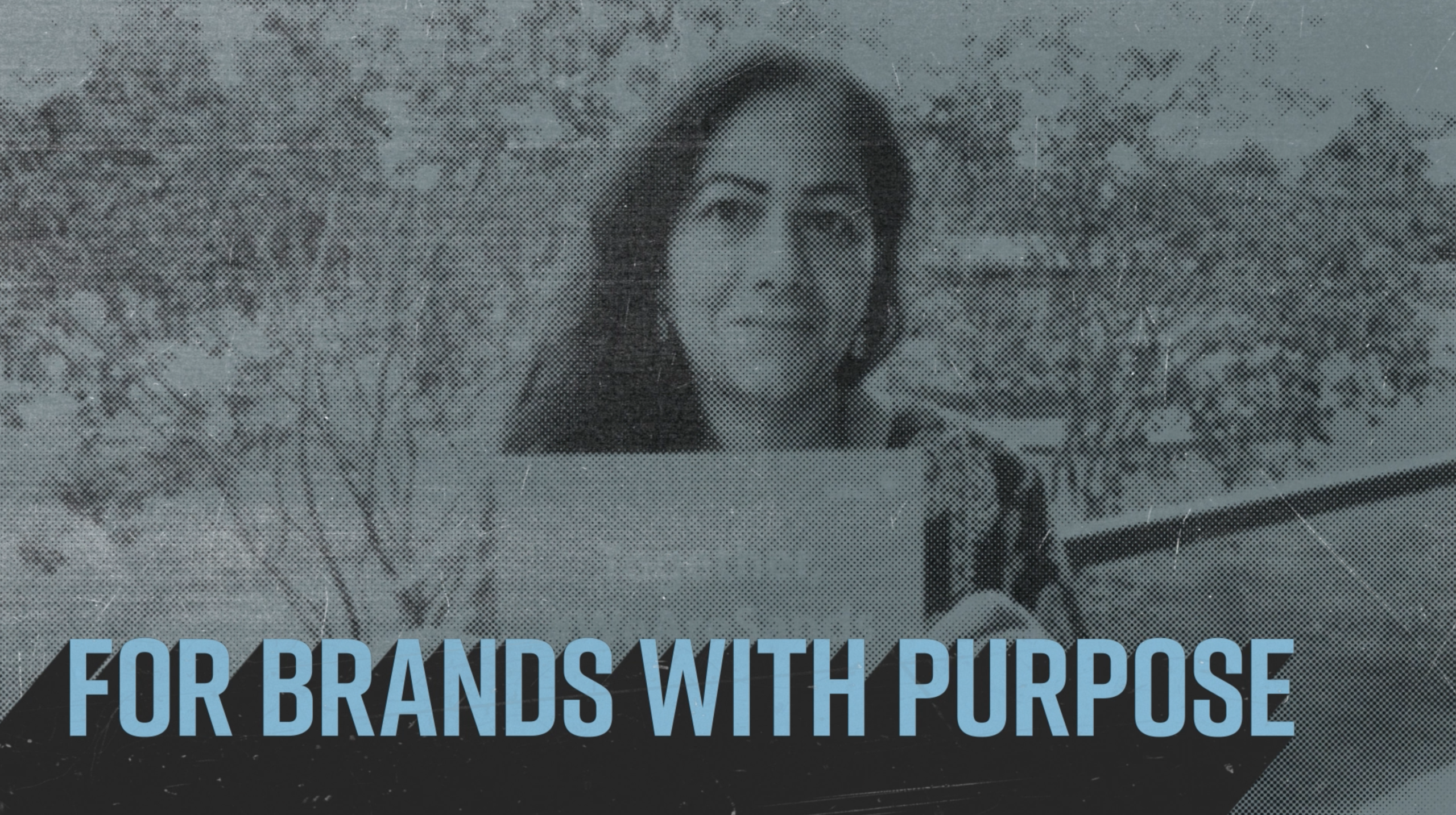 Video production still showing a halftone image of a woman holding a charity placard above the caption 'for brands with purpose'
