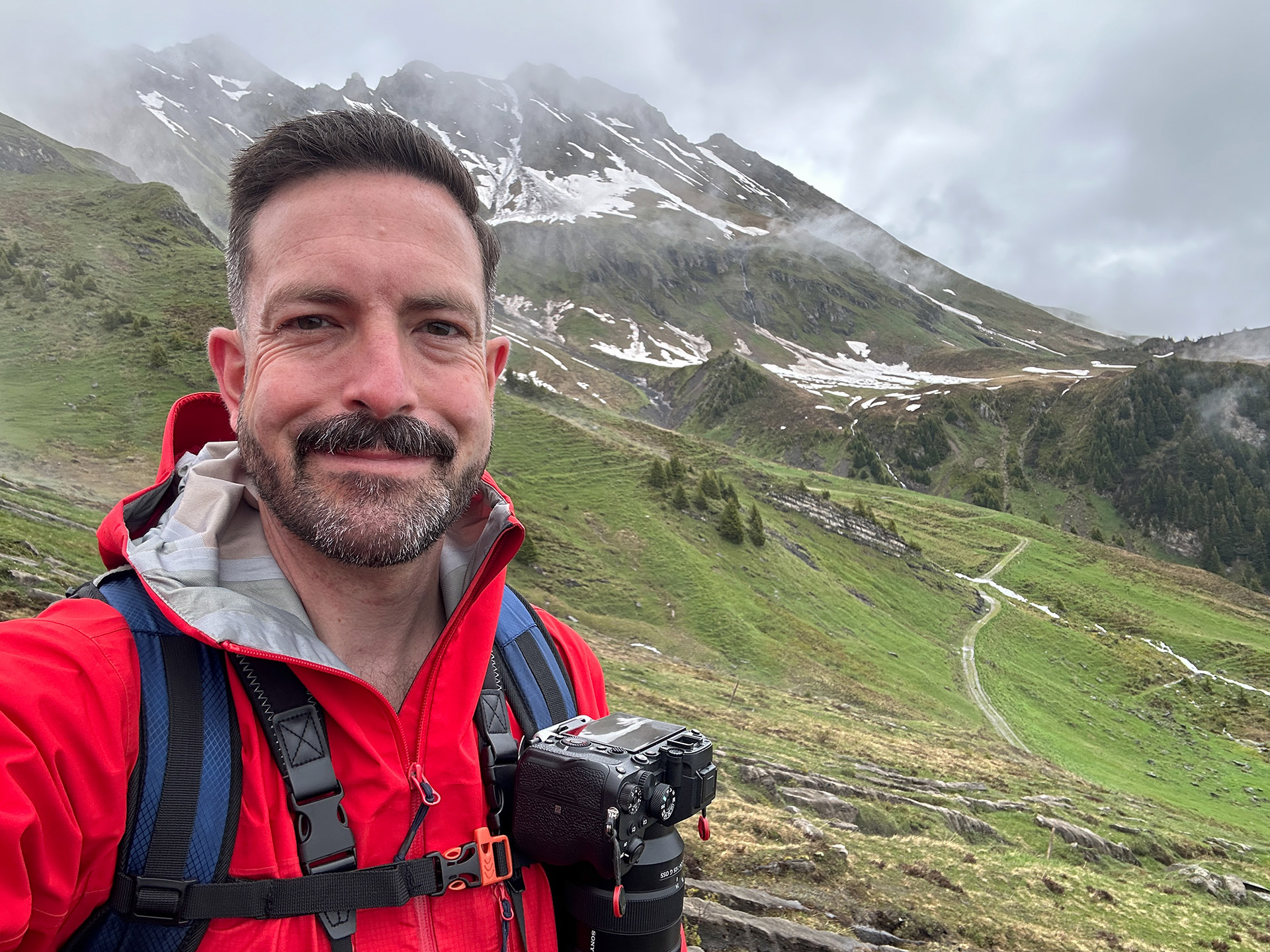 Charity videographer with professional camera equipment in mountain location, combining travel journalism experience with video production services
